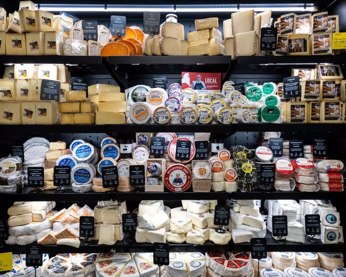 A view of a very well-stocked cheese section at Whole Foods